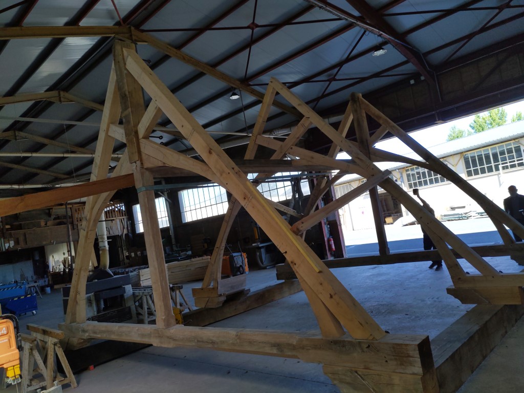 Nouvelle charpente en bois assemblée dans l'atelier du charpentier avant sa pose sur l'église Saint Paul de Reilhac