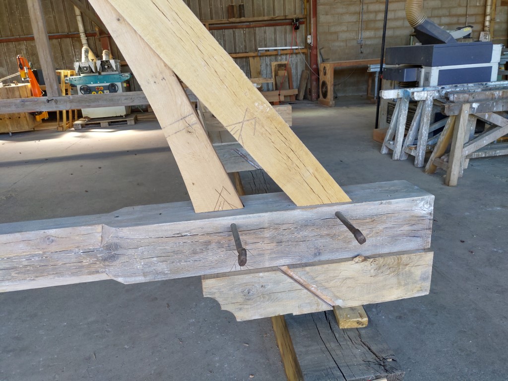 Poutre de charpente en cours de façonnage dans l'atelier, pour la rénovation de l'église Saint Paul de Reilhac